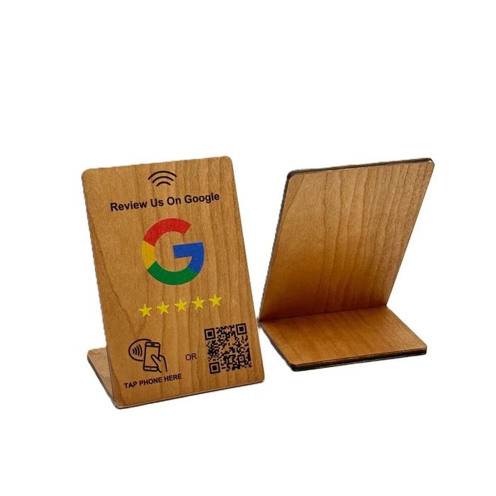 Front and rear views of a wooden stand with printed review artwork, a tap prompt and a QR code.